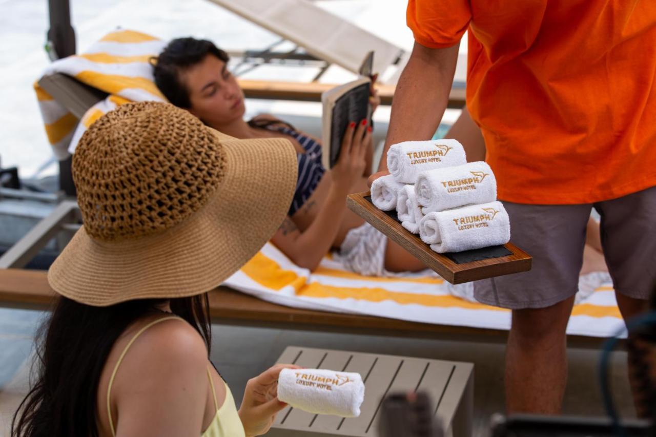 Triumph Luxury Hotel Kairo Bagian luar foto A hotel staff member serves guests at a poolside bar