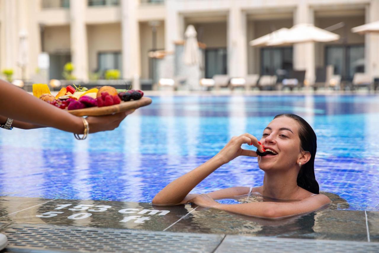 Triumph Luxury Hotel Kairo Bagian luar foto A woman in a swimming pool